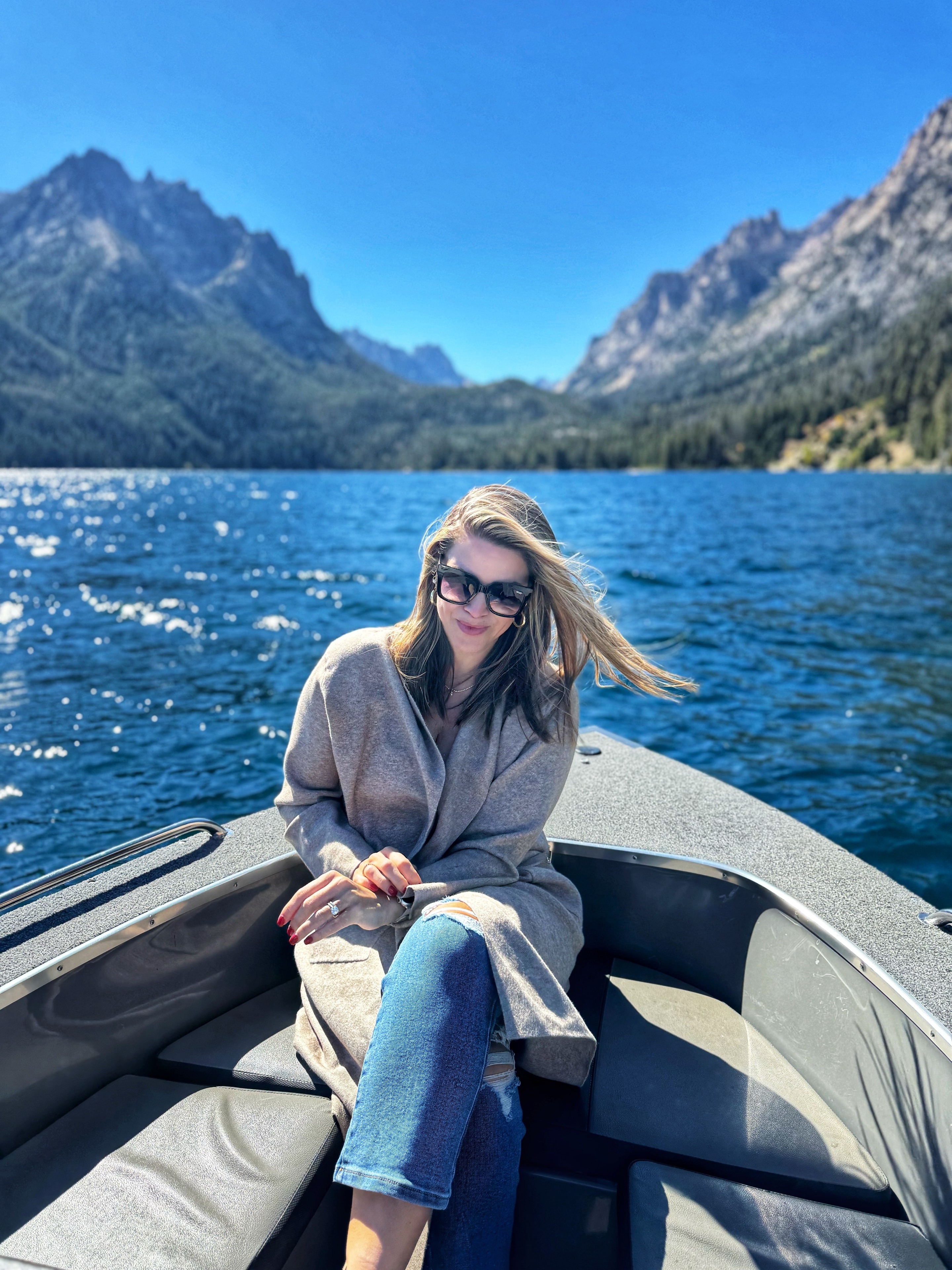 Camila on a boat with mountain lake scenery