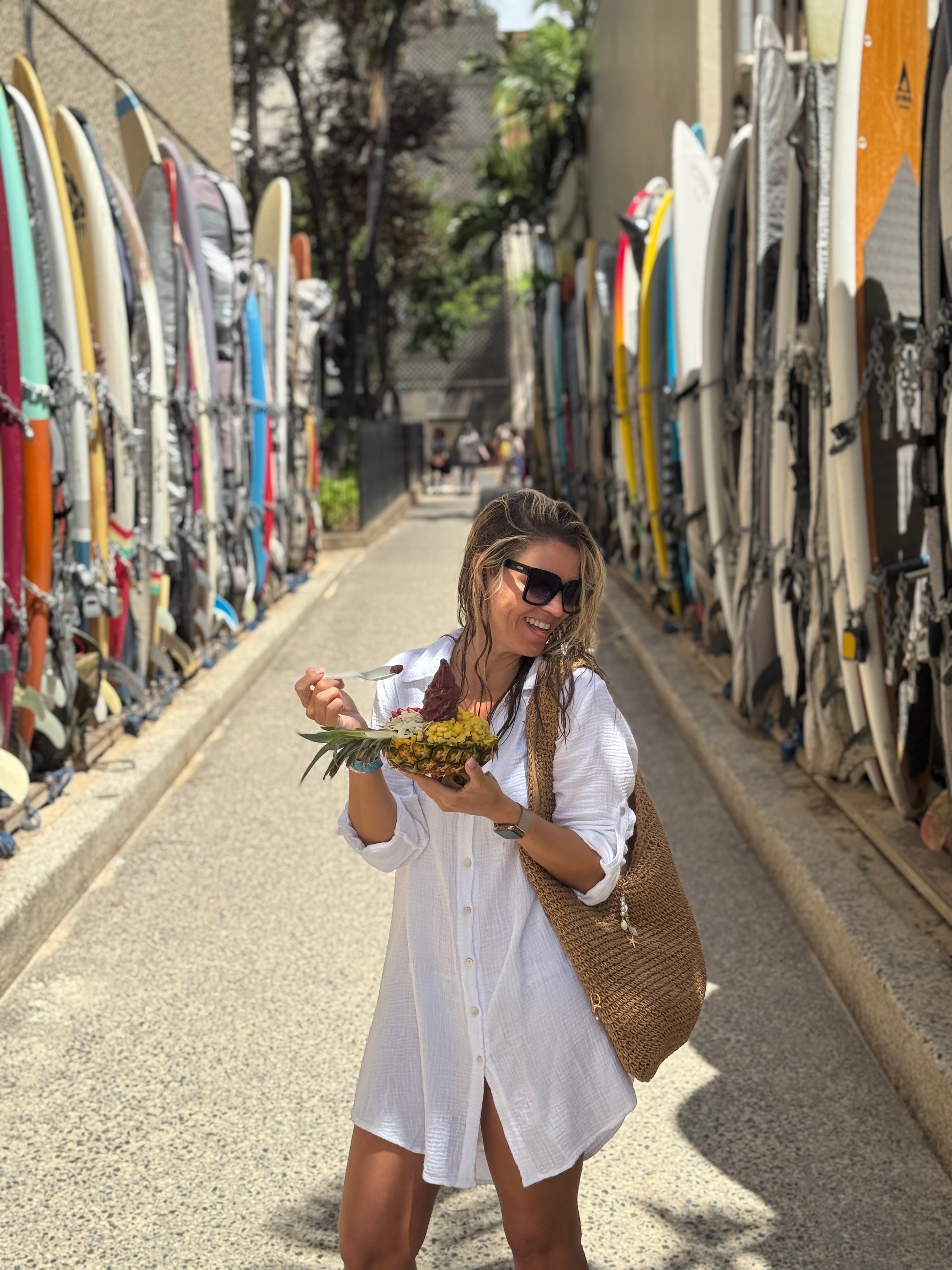 Camila in surfboard alley holding pineapple